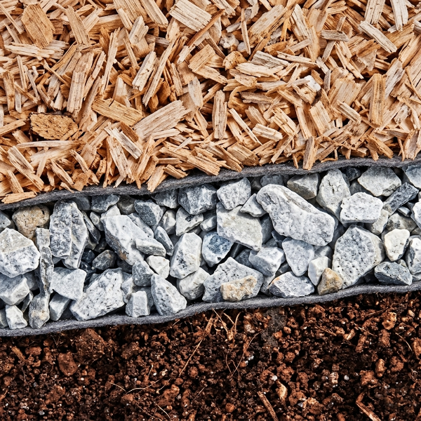 Engineered wood fiber playground surfacing system with stone drainage layer geotextile fabric and sub base for safety