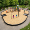 Playground with engineered wood fiber surfacing and timber borders showing safe fall protection area around swings and play structure