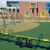 School playground with poured in place rubber surfacing providing ADA accessible safety flooring around swings and play equipment
