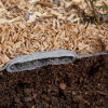 Engineered wood fiber playground surfacing system with drain layer geotextile fabric and sub base for improved drainage