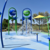 Interactive splash pad with spray features installed on seamless rubber surfacing for safe non slip aquatic play areas